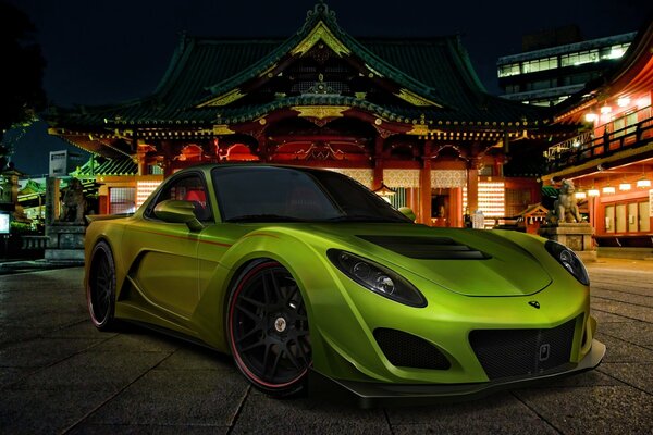 Green Mazda on the background of the night street of the Chinese city