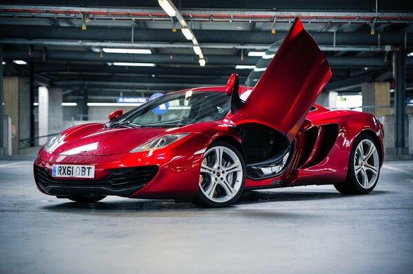 McLaren rojo en el estacionamiento de lado