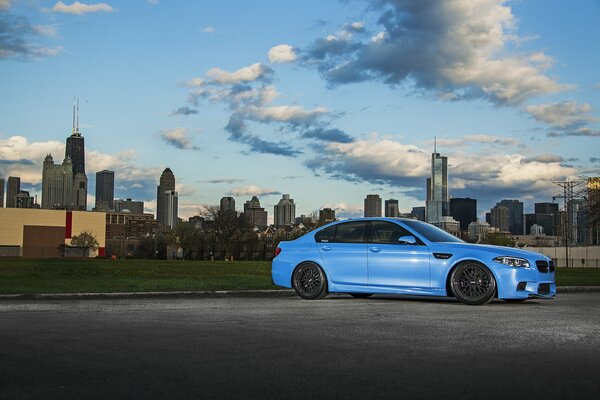 La couleur bleue extraordinaire de BMW sur le fond de la jungle urbaine