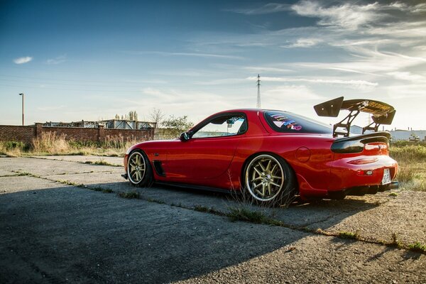 Sur les vieilles dalles de béton rouge sport Mazda avec spoiler arrière