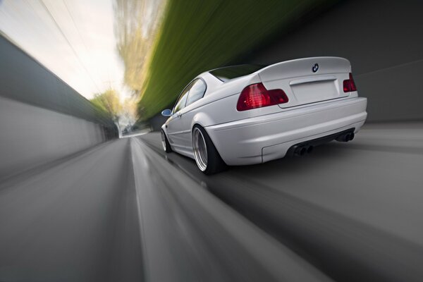 Un elegante BMW blanco corre por la carretera