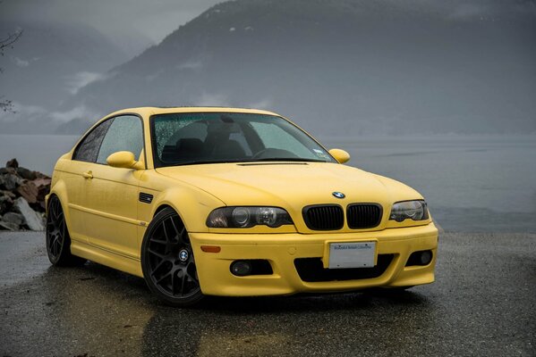 Voiture de sport bmw jaune sur asphalte mouillé