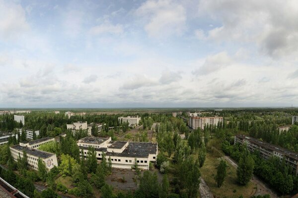Pripyat techos de casas, cielos ahumados y copas de árboles