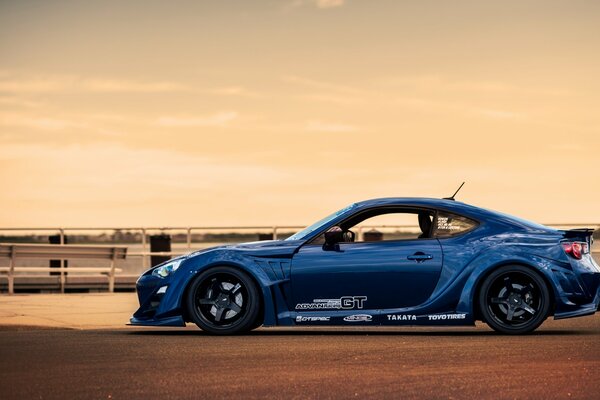 Profil d une voiture bleue au coucher du soleil rose