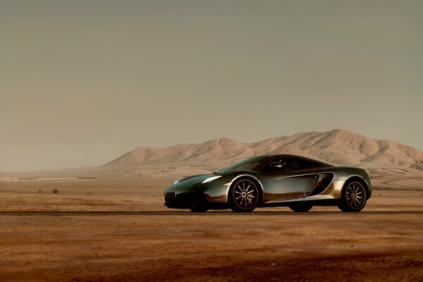 McLaren in the desert with a mountain range in the background