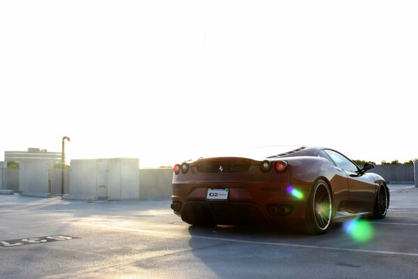 Ferrari Rosso scuro nei raggi del sole. Riflesso