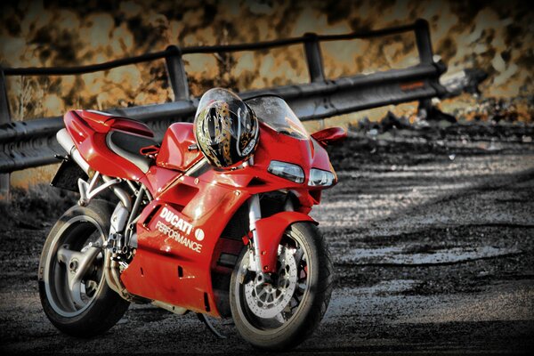 Red Sports Motorcycle with Helmet Weighing on Gas Handles