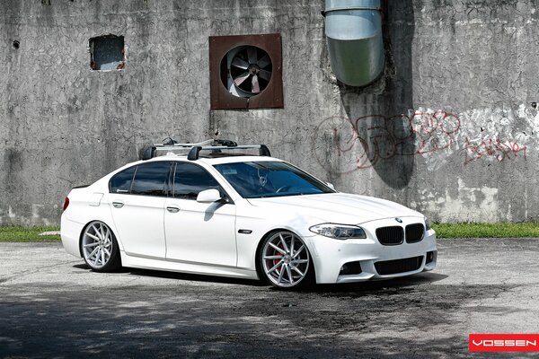 Weißer BMW auf grauem Wandhintergrund