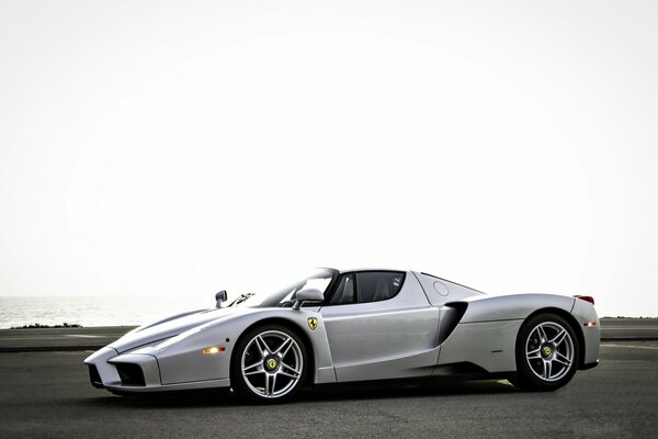 Silver Ferrari in the parking lot. The sea in the background