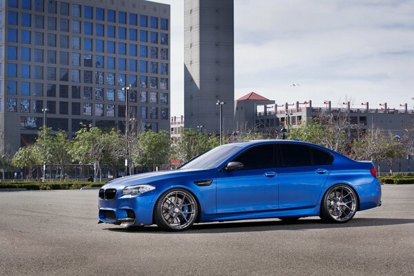 Blue BMW car on the background of a multi-storey building