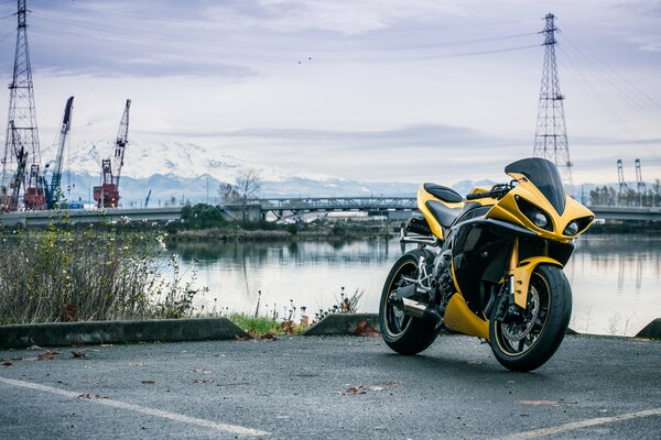 Żółty motocykl na brzegu rzeki
