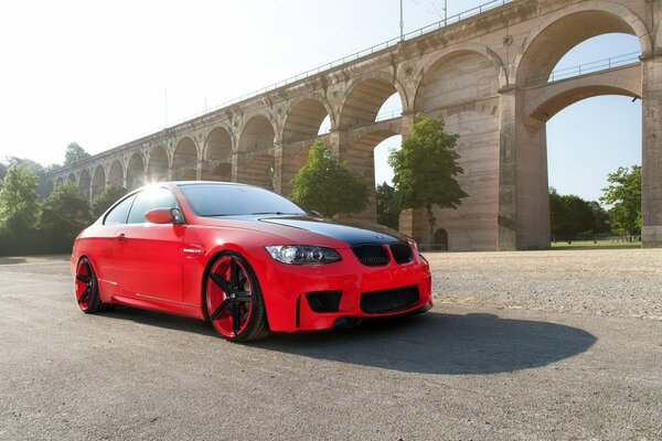 The shadow of a red BMW on the asphalt