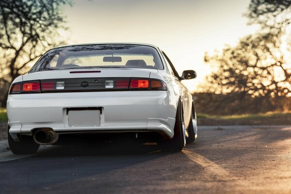 Nissan white on the road - rear view