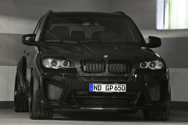 Czarne BMW na tle szarej ściany