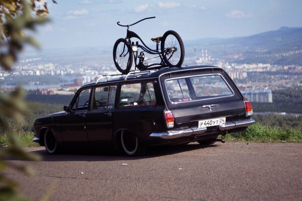 Volga raro con una bicicletta sul tetto sullo sfondo della città