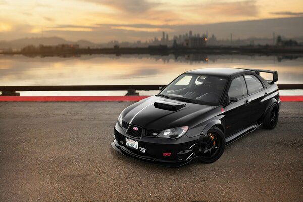 Subaru impreza negro en el fondo de la ciudad