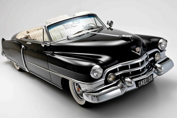 Su uno sfondo bianco, la leggendaria Cadillac nera chic con una parte superiore aperta