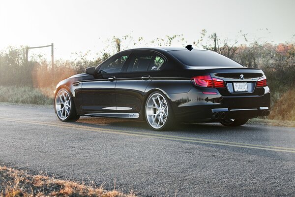 BMW negro en la carretera con marcas