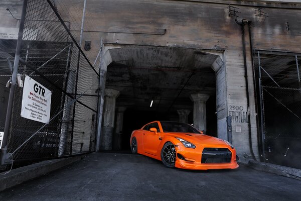 Nissan naranja contra la abertura negra del edificio