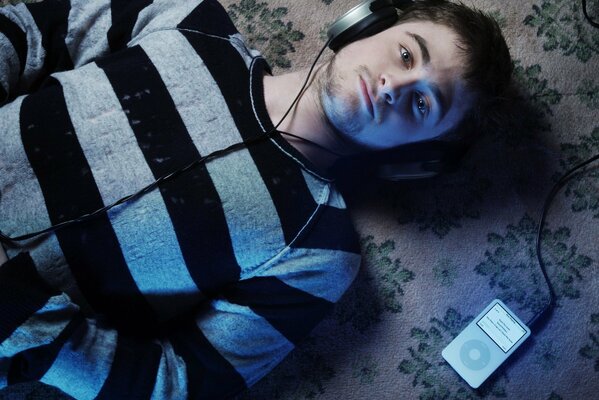 Actor Daniel Radcliffe from Harry Potter wearing headphones on the floor