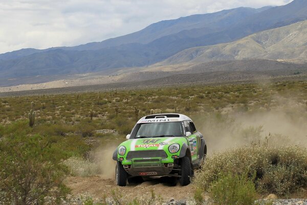 Mini Cooper im Sport Dakar auf dem Hintergrund der Berge