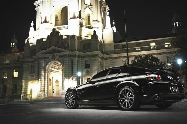 Retro photo of a black Mazda car on a night street