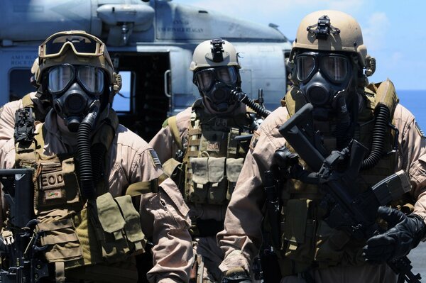 Soldiers with weapons on the background of a helicopter