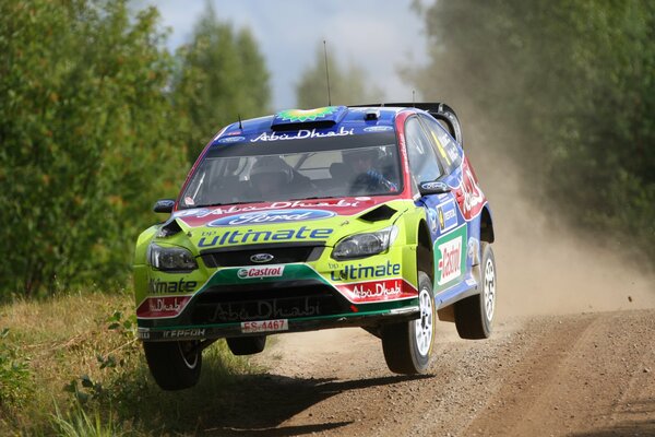 Un Ford de carreras vuela por un camino de tierra 