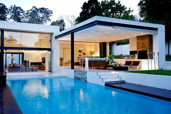 Vue de la fenêtre de la maison sur la piscine bleue