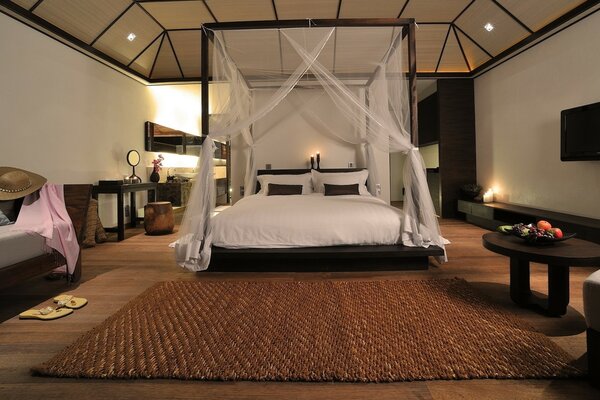 Łóżko z baldachimem i stylowym dywanem