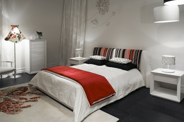 White bed with red blanket