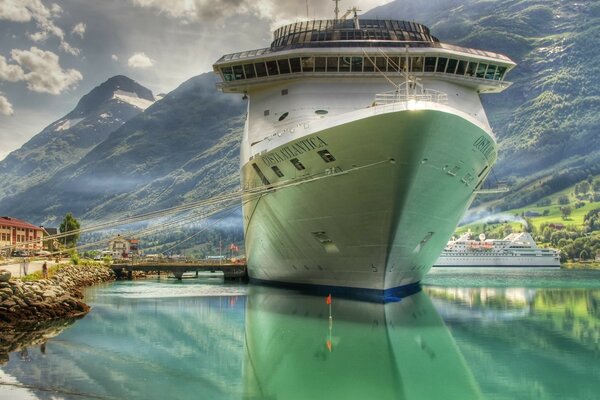 Liner am Steg vor dem Hintergrund der Berge