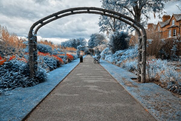 Ein Weg durch einen Bogen durch einen schönen Garten