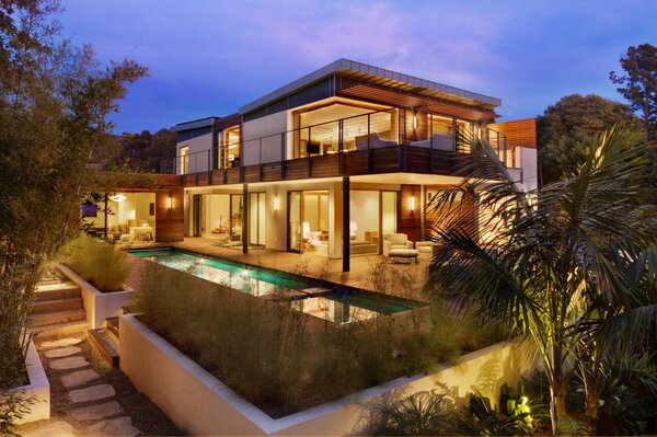 Large villa with yellow lights in the evening twilight