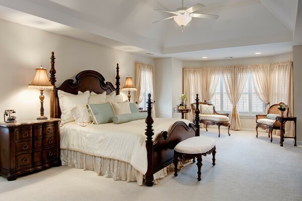 Camera da letto di design in colori chiari con ventilatore lampadario sul soffitto
