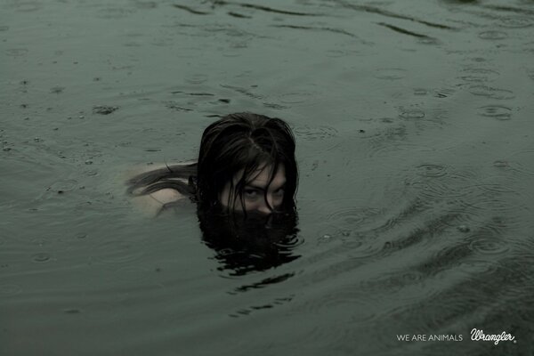 A girl gets out of the water in the rain