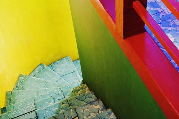 A steep stone staircase descending down among colorful bright walls