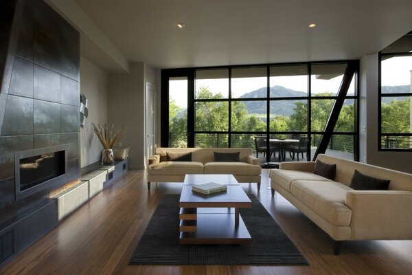 Salon-living room in minimalist style with a white sofa, bio fireplace and panoramic window