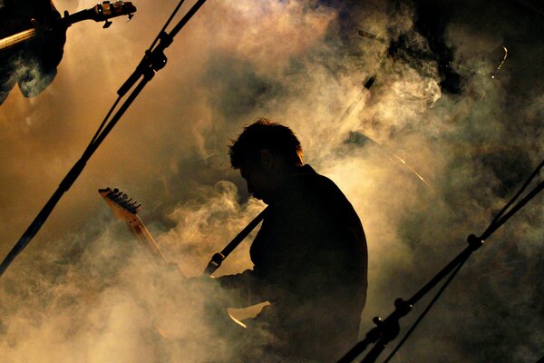 Guitarist at a concert in spectacular smoke