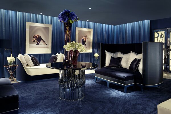 Living room in blue tones, stylized as a modern theater with photos of ballet dancers on the walls