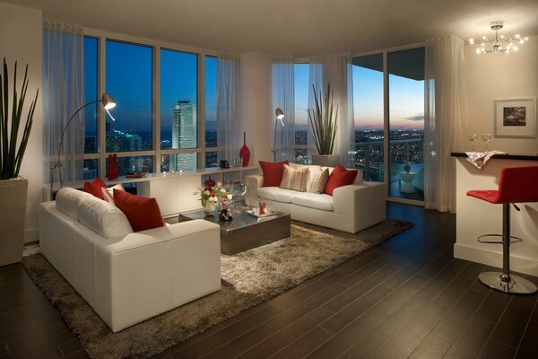 Luxuriöses Wohnzimmer mit weißen Sofas in Miami Apartments mit Blick auf die Nachtstadt