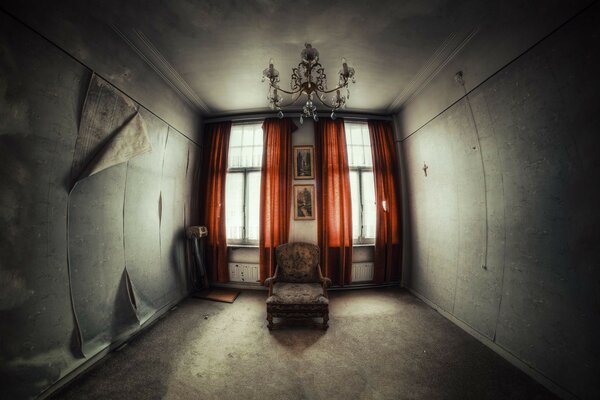 A chair in an abandoned room by the window