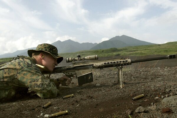 Un francotirador en las montañas con un rifle dispara