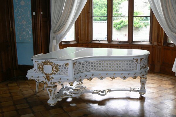 Piano de luxe près de la fenêtre avec des rideaux blancs