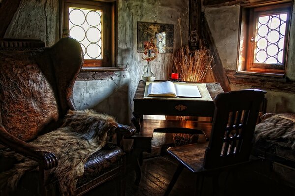 La esquina de la habitación en la que vemos la silla, la silla y el libro abierto en el Escritorio