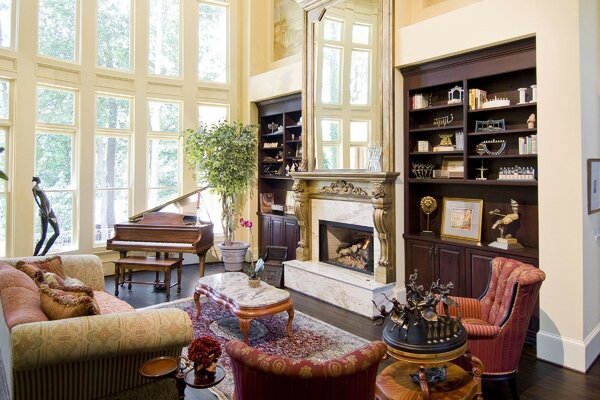 A room with a beautiful fireplace and a grand piano