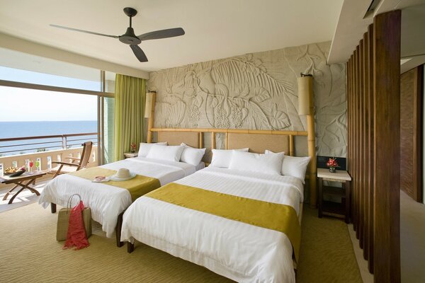 Room design, bed with white and green bed linen, sea outside the window