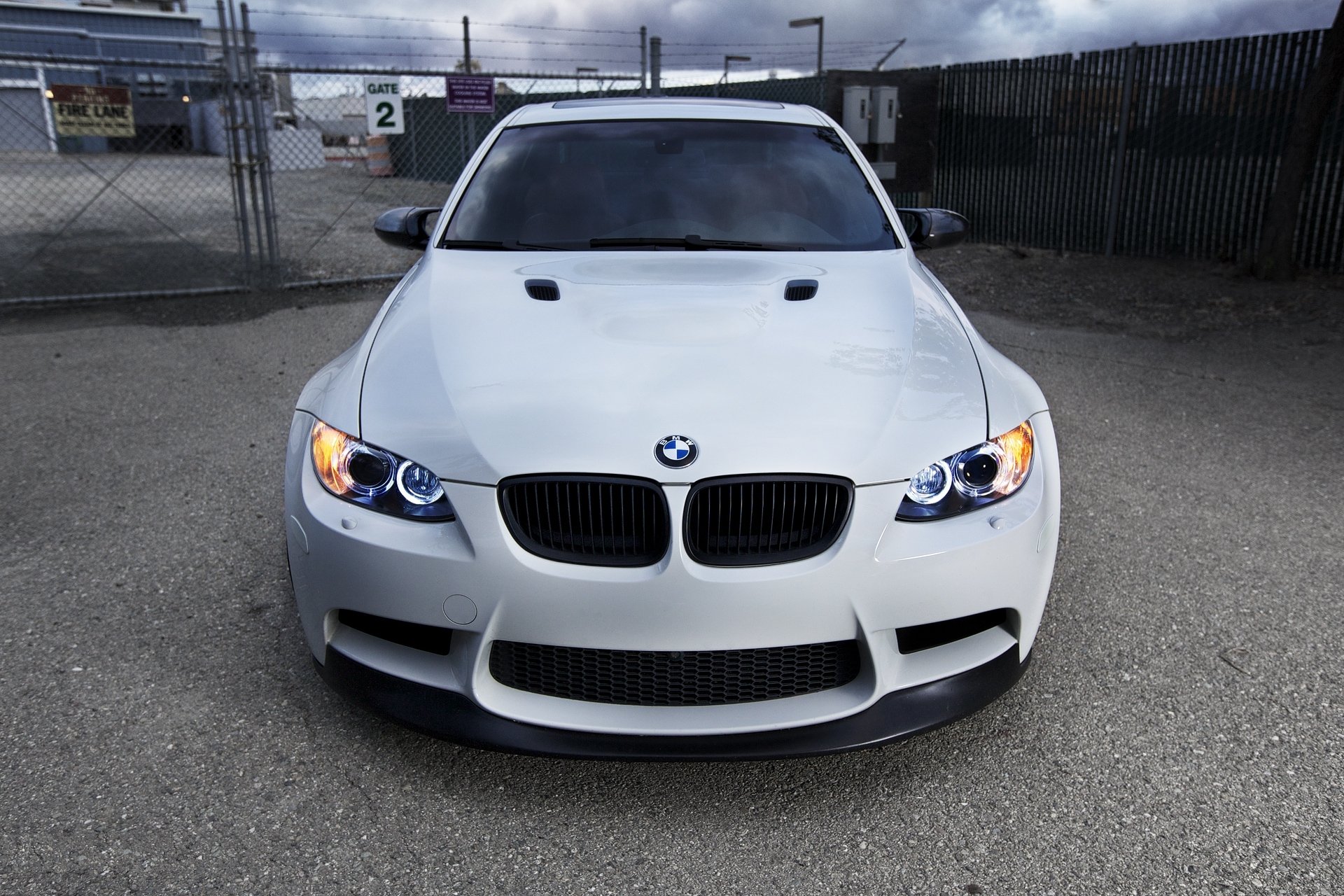 bmw m3 e90 white bmw headlights daylight fence gate barbed wire