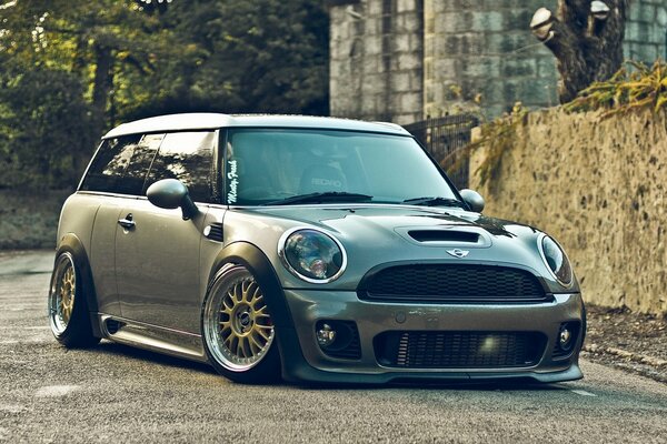 The tuned front of the mini Cooper in country style on the background of the wallpaper of the style of Stans