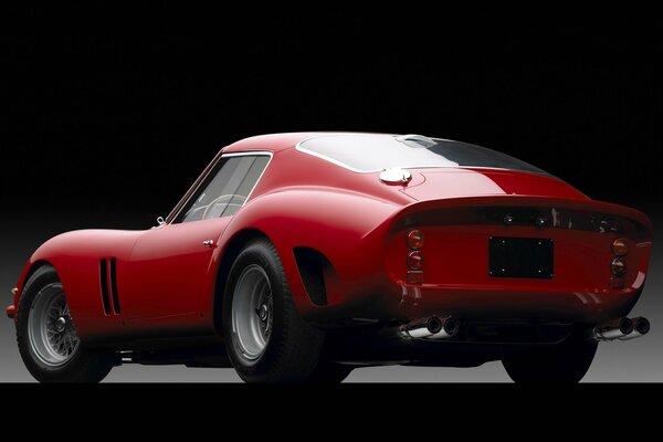 An unusual, red car on a dark background. Rear view